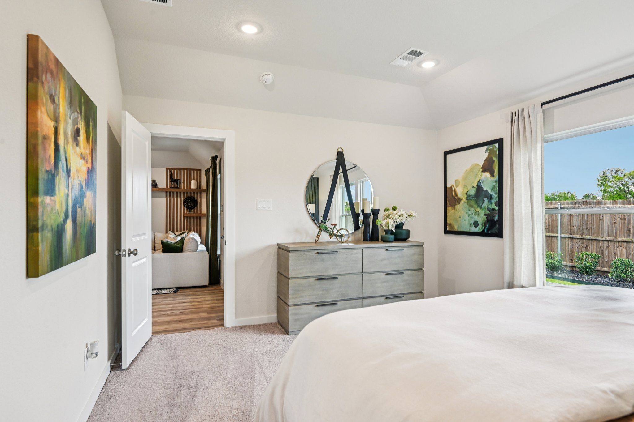 A bedroom with a large mirror.