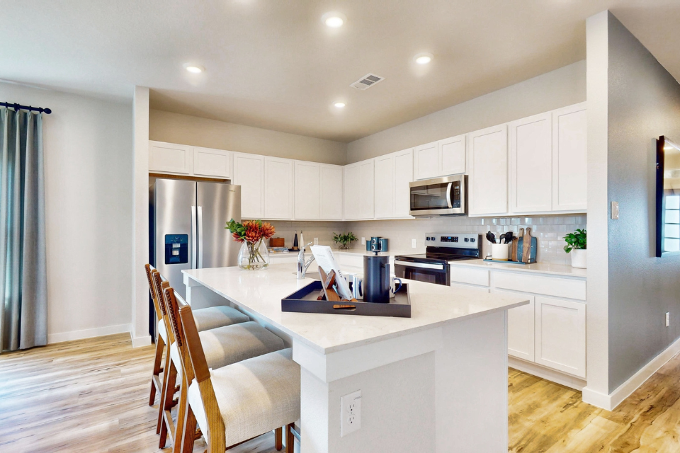 A kitchen with white cabinets.