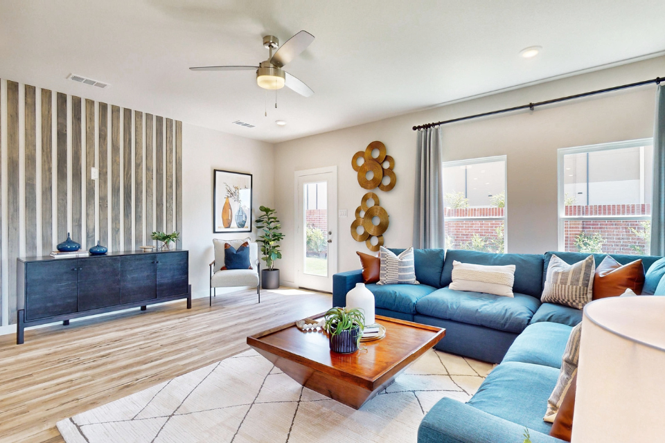 A living room with a blue couch and a wood floor.
