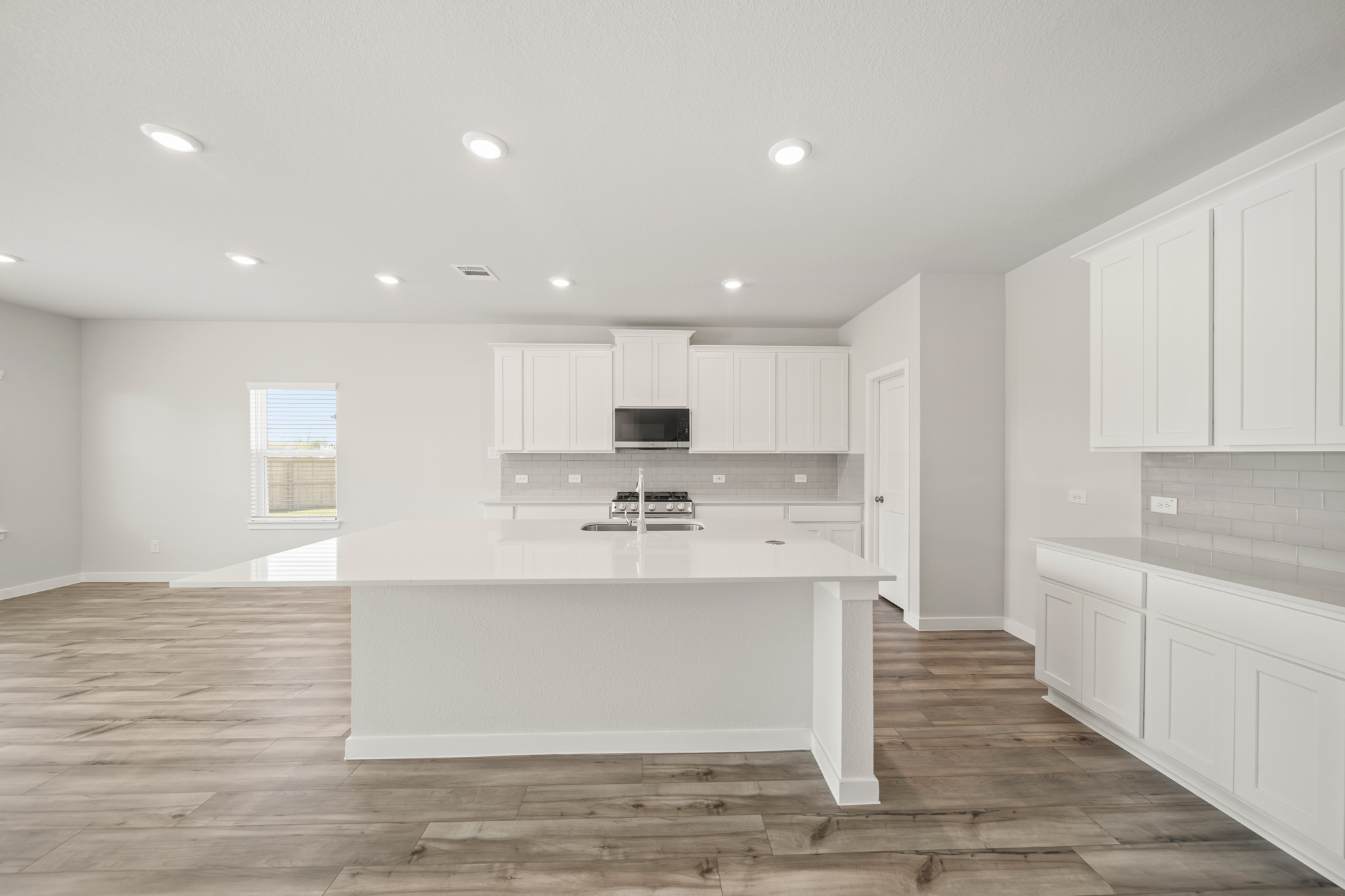 A kitchen with white cabinets.