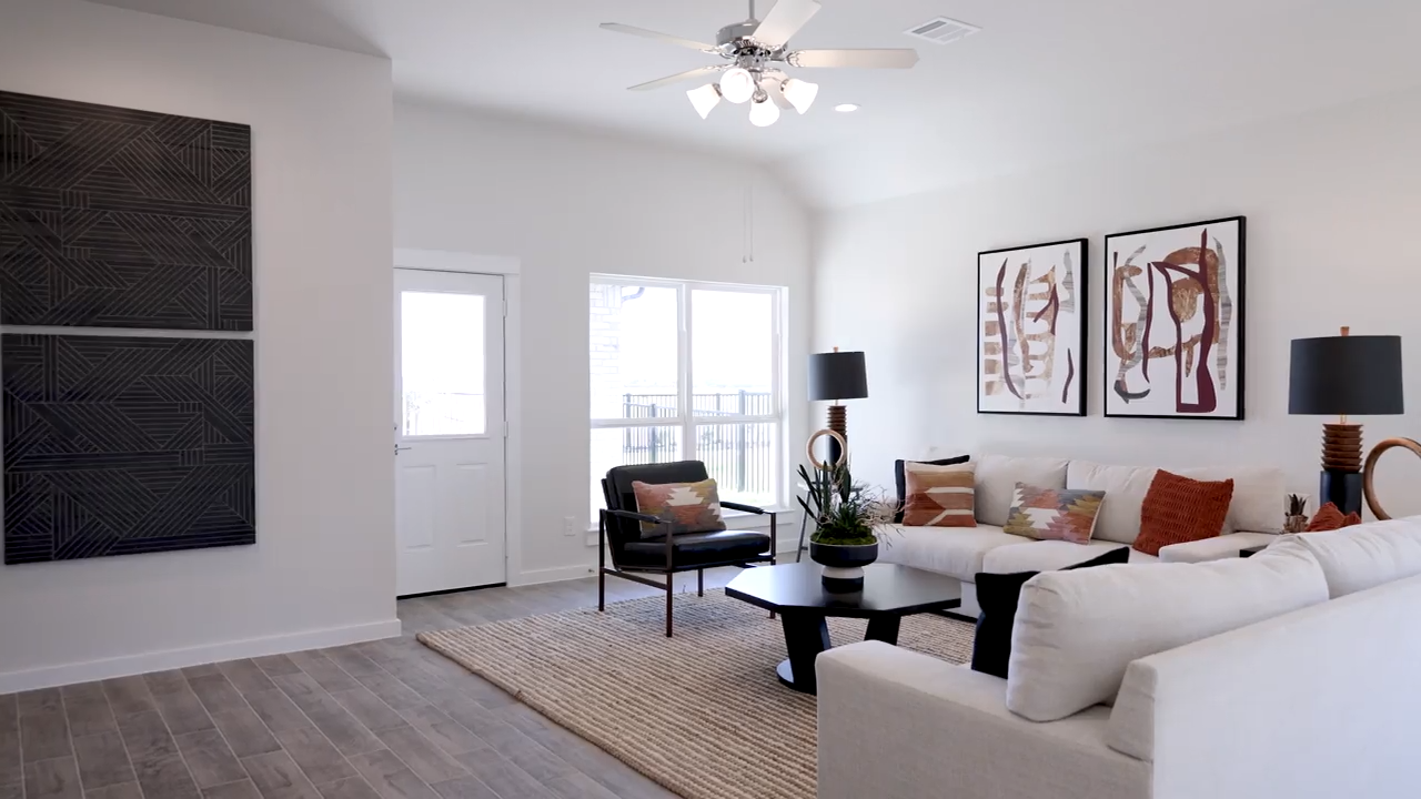 A living room with a white couch and a ceiling fan.