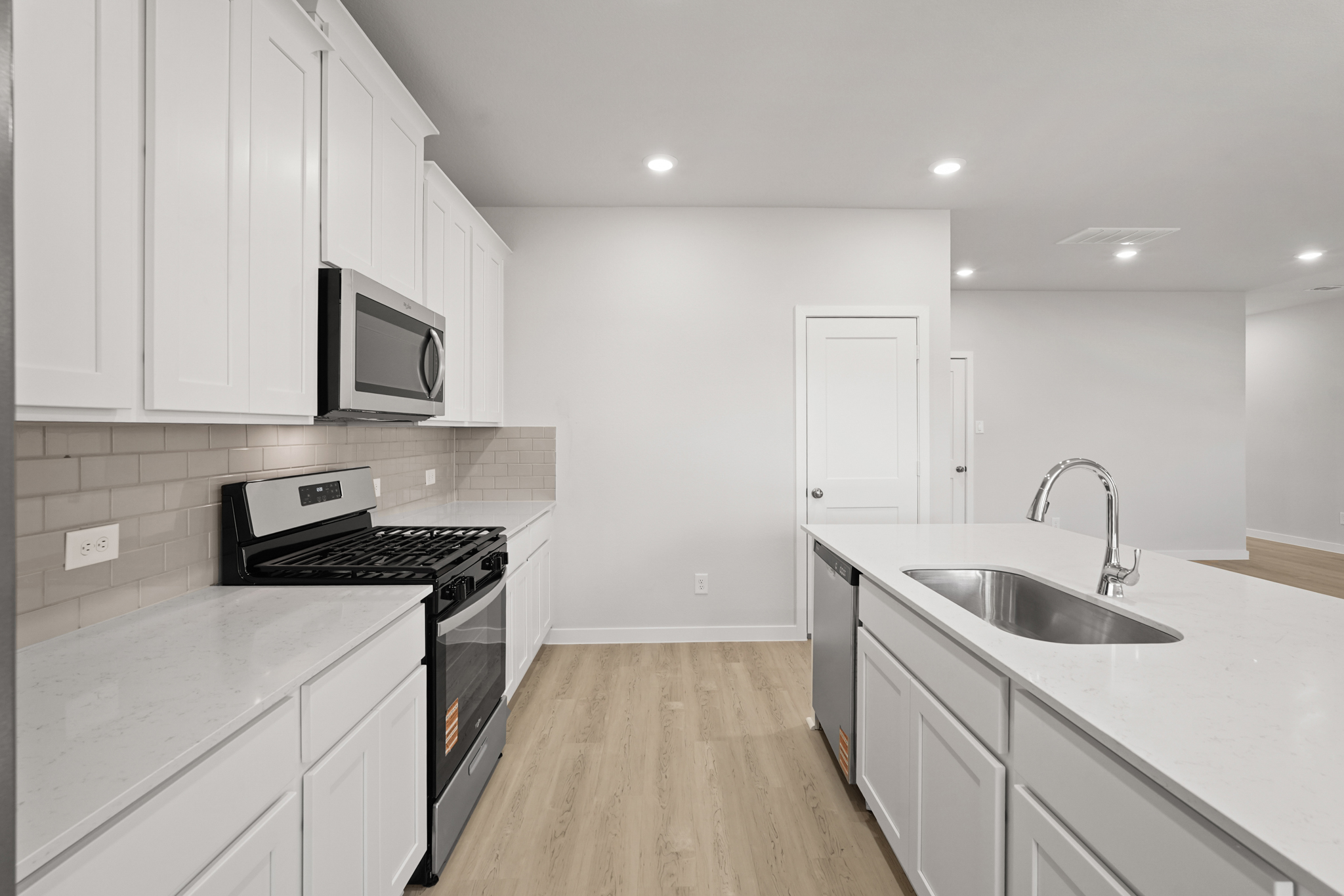 A kitchen with white cabinets.
