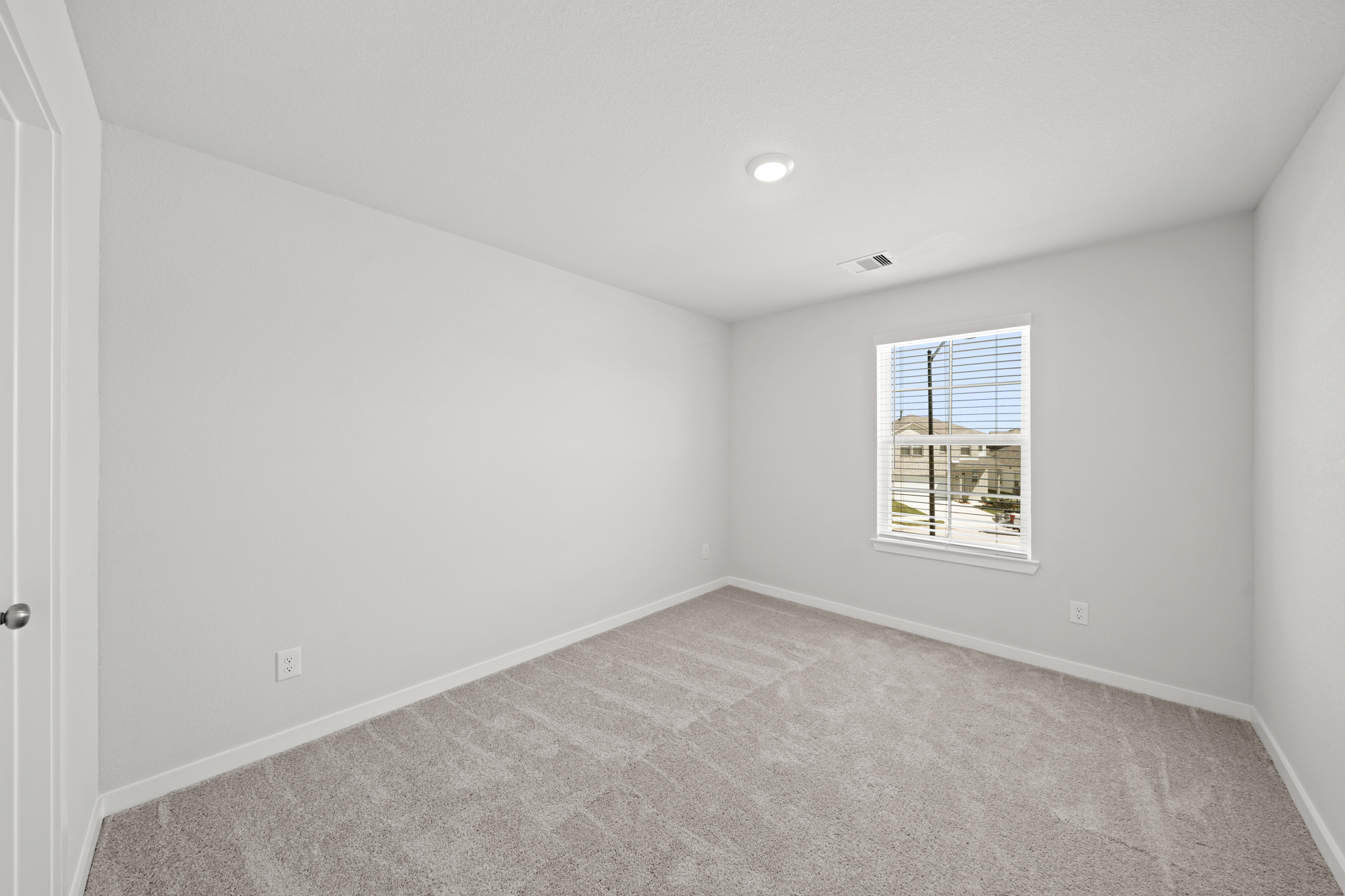 A room with a window and a carpet.