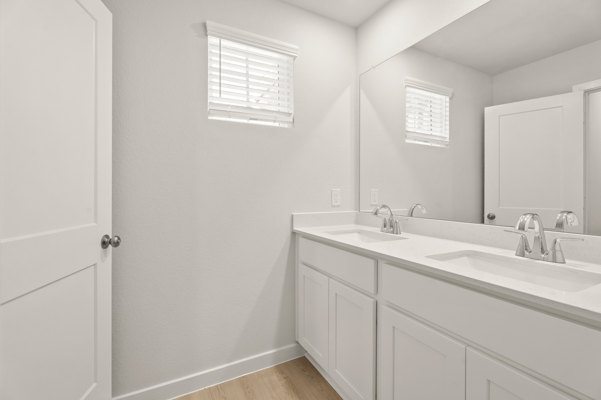A bathroom with white cabinets.