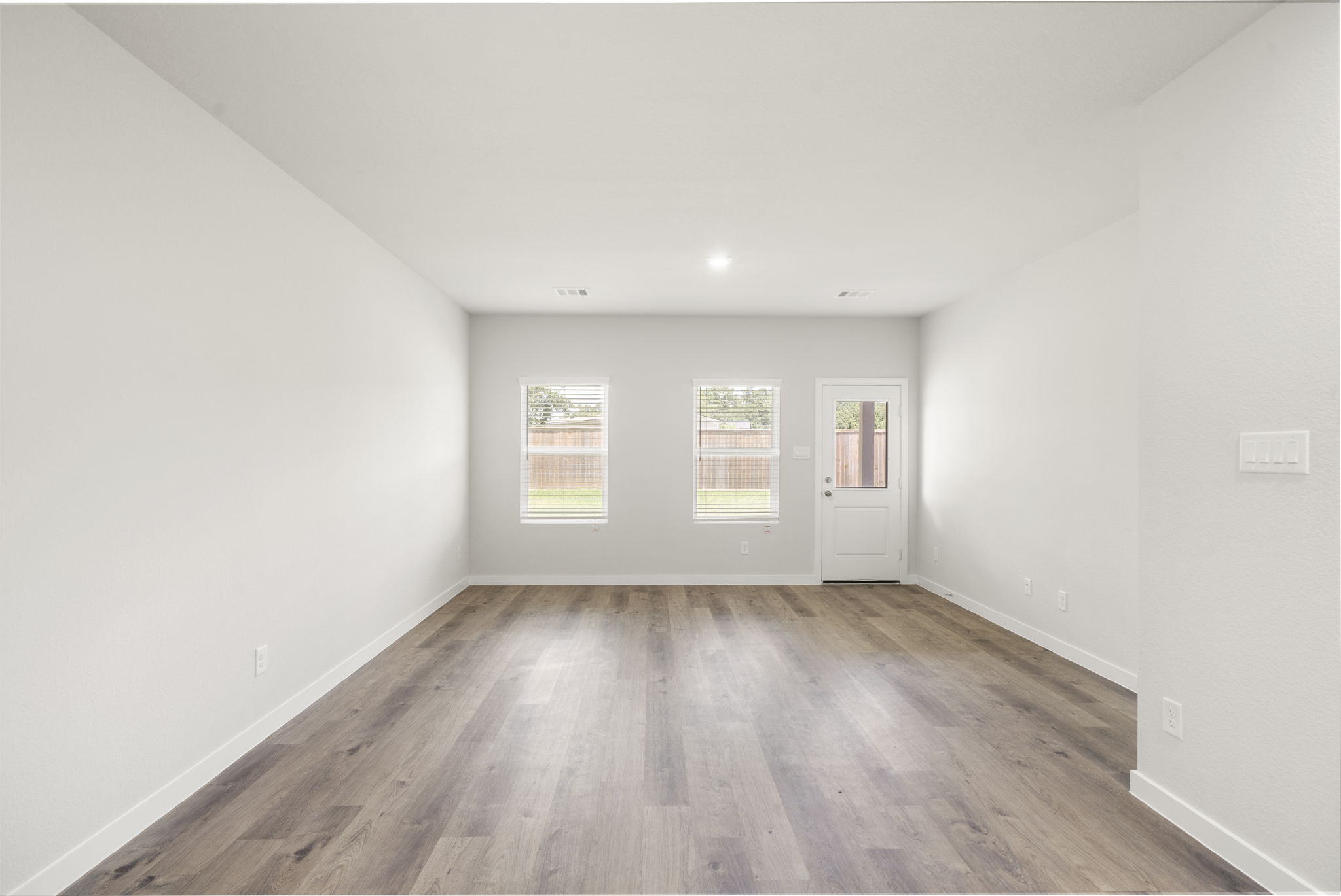 A room with a wood floor and white walls.