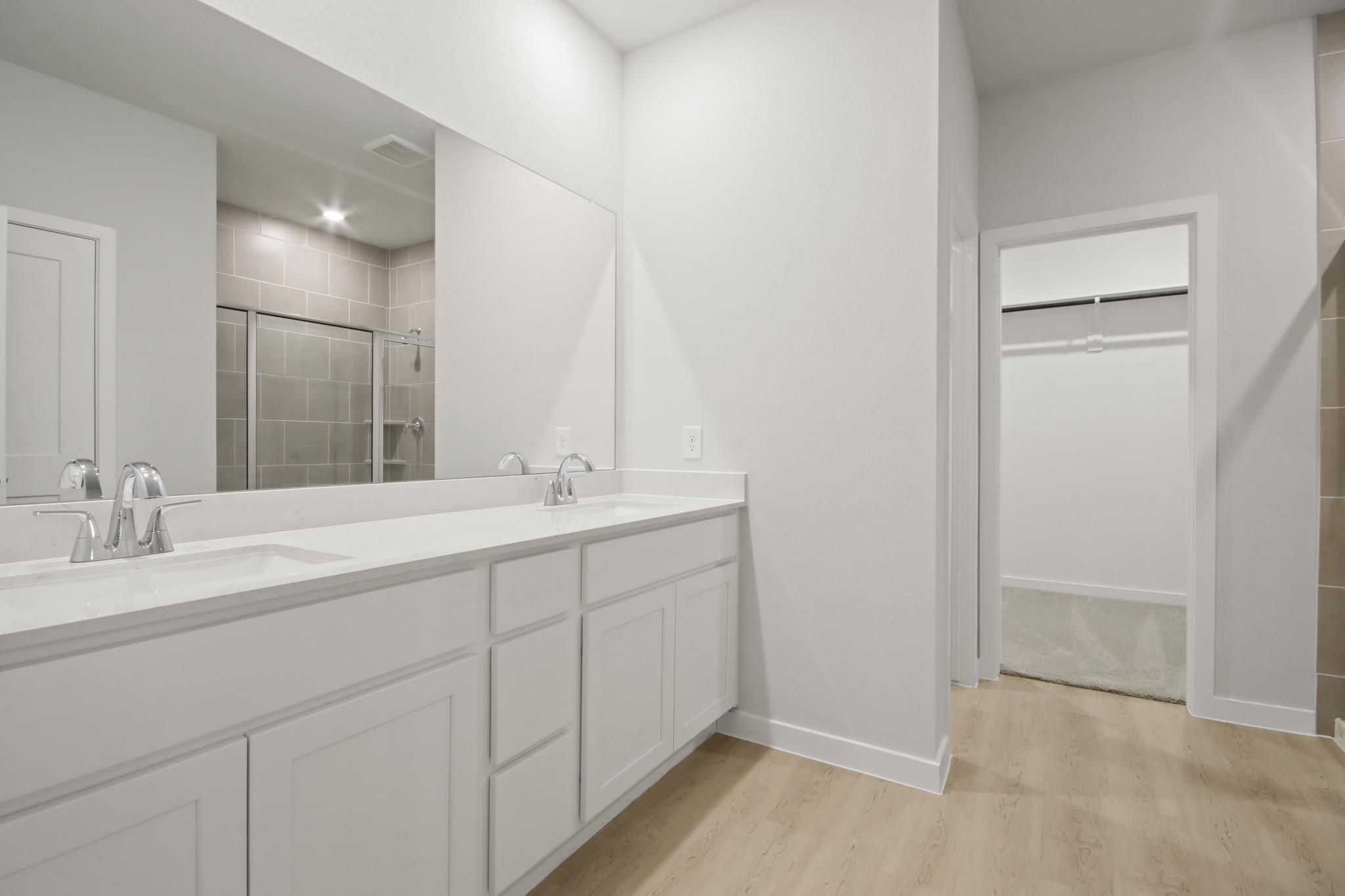 A bathroom with white cabinets.