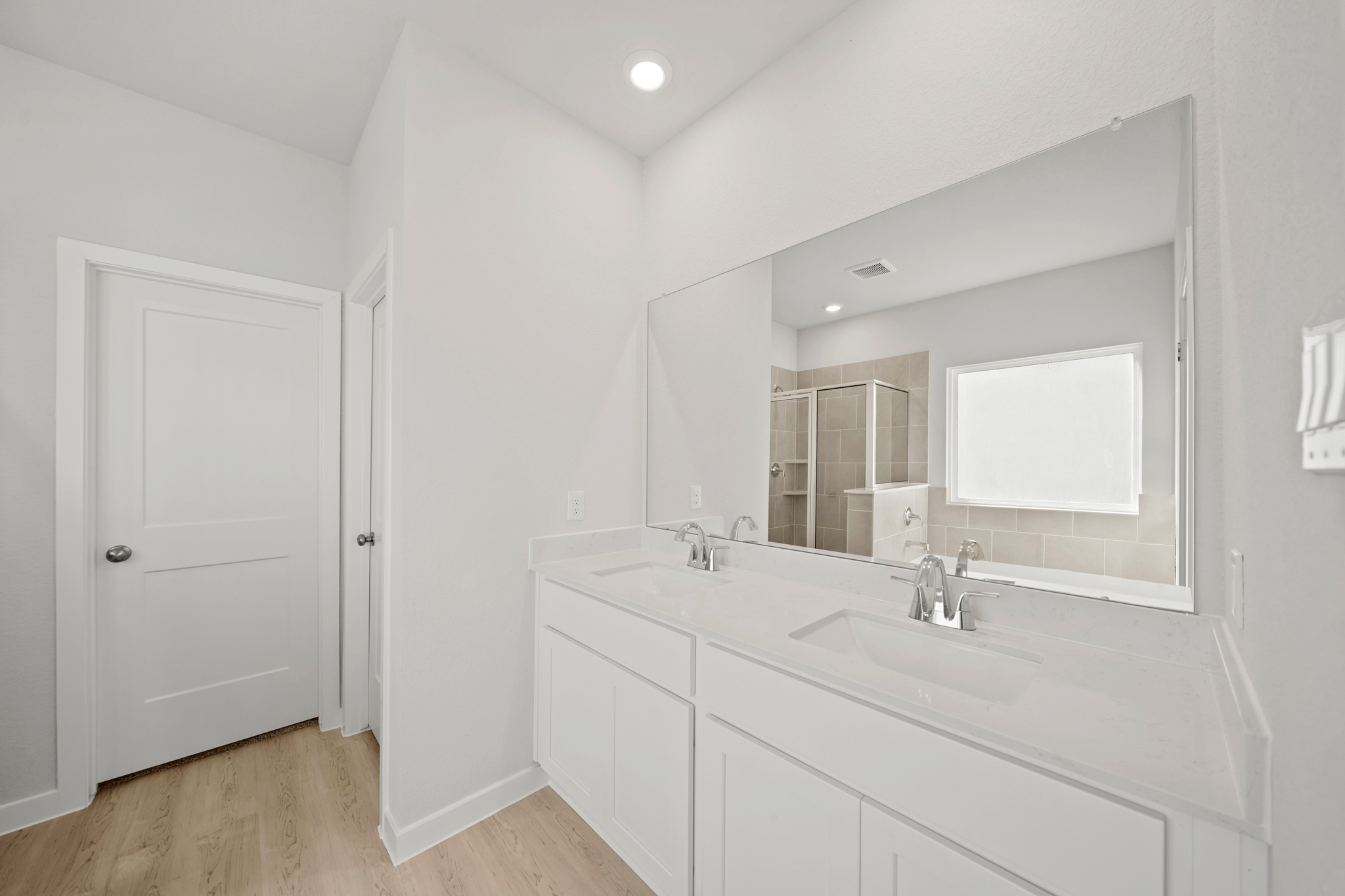 A bathroom with white cabinets.