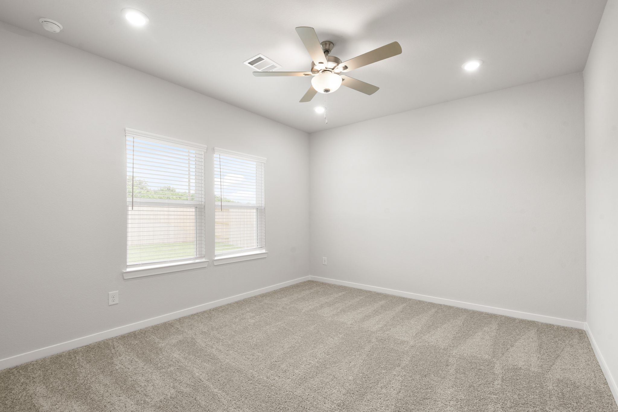 A room with a ceiling fan and a window.