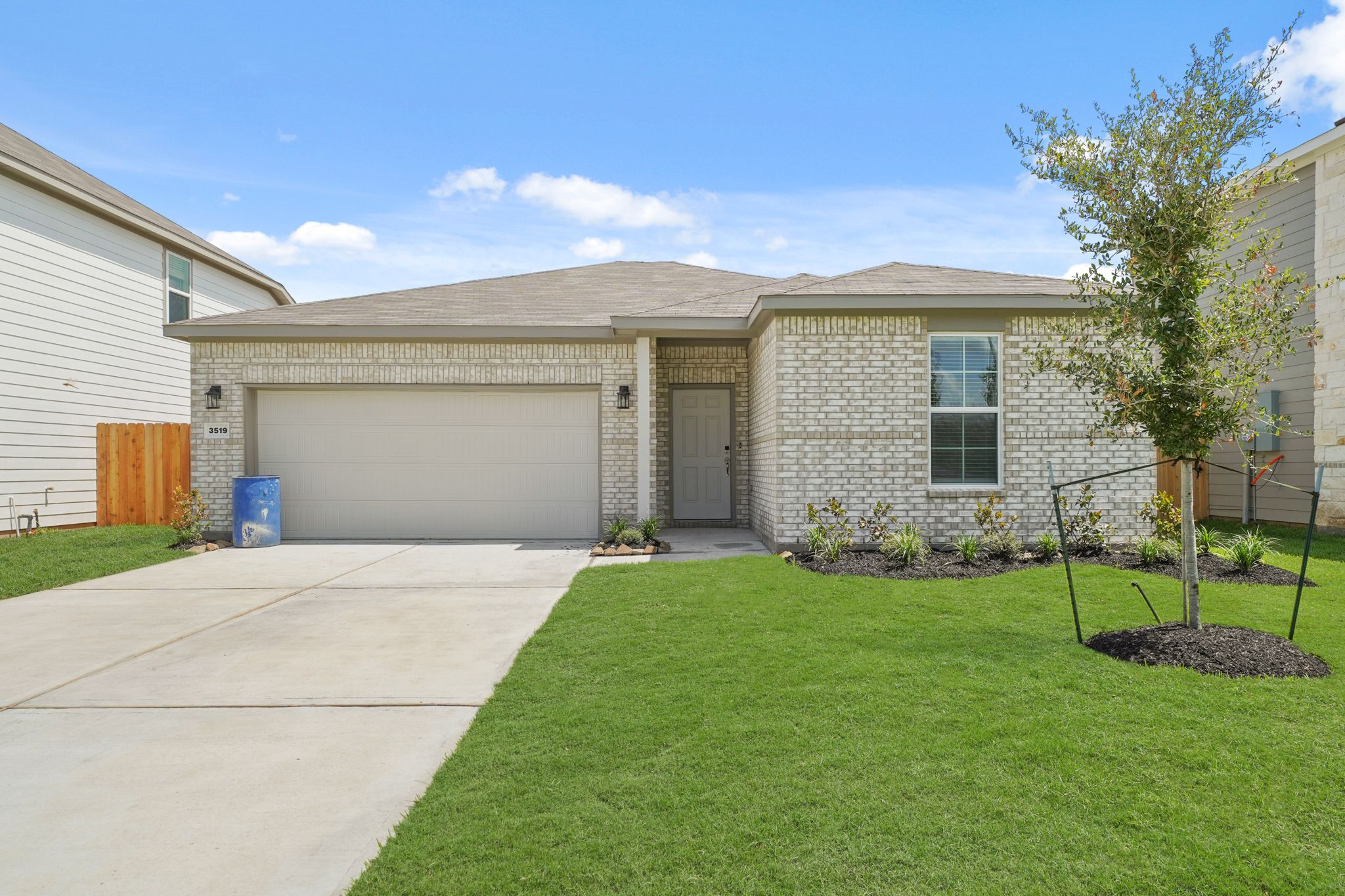 A house with a garage and a tree in the front.