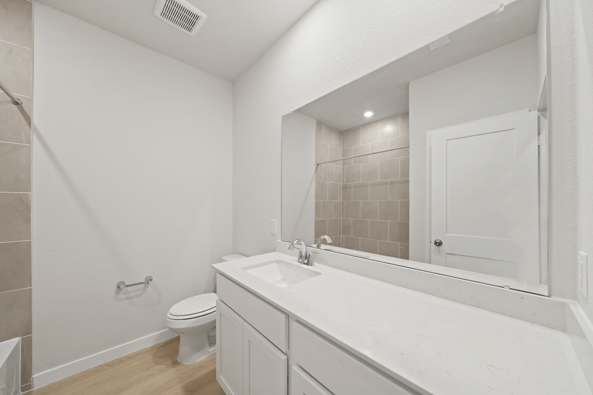 A bathroom with a tub sink and toilet.