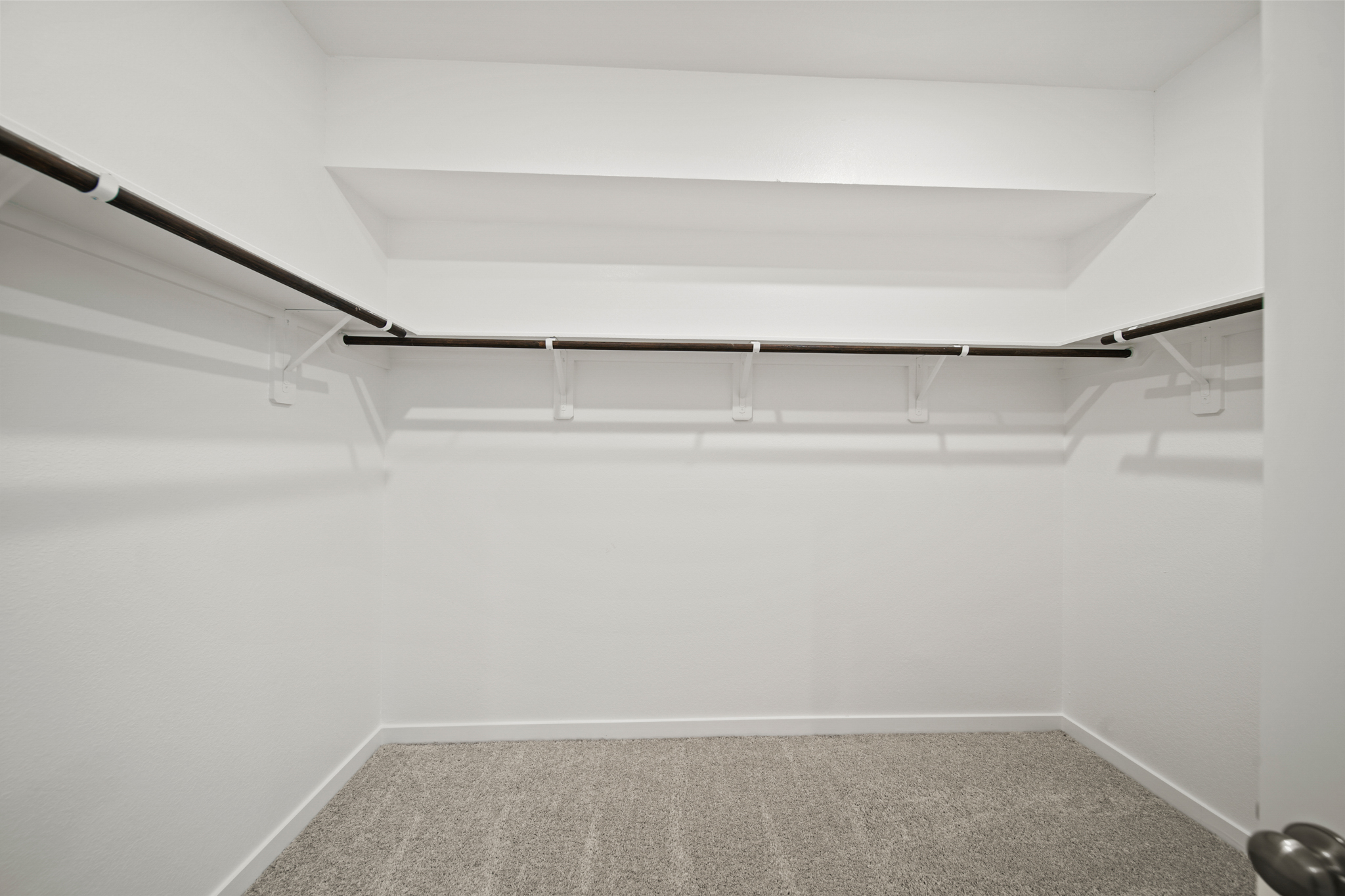 A white room with a black carpet.