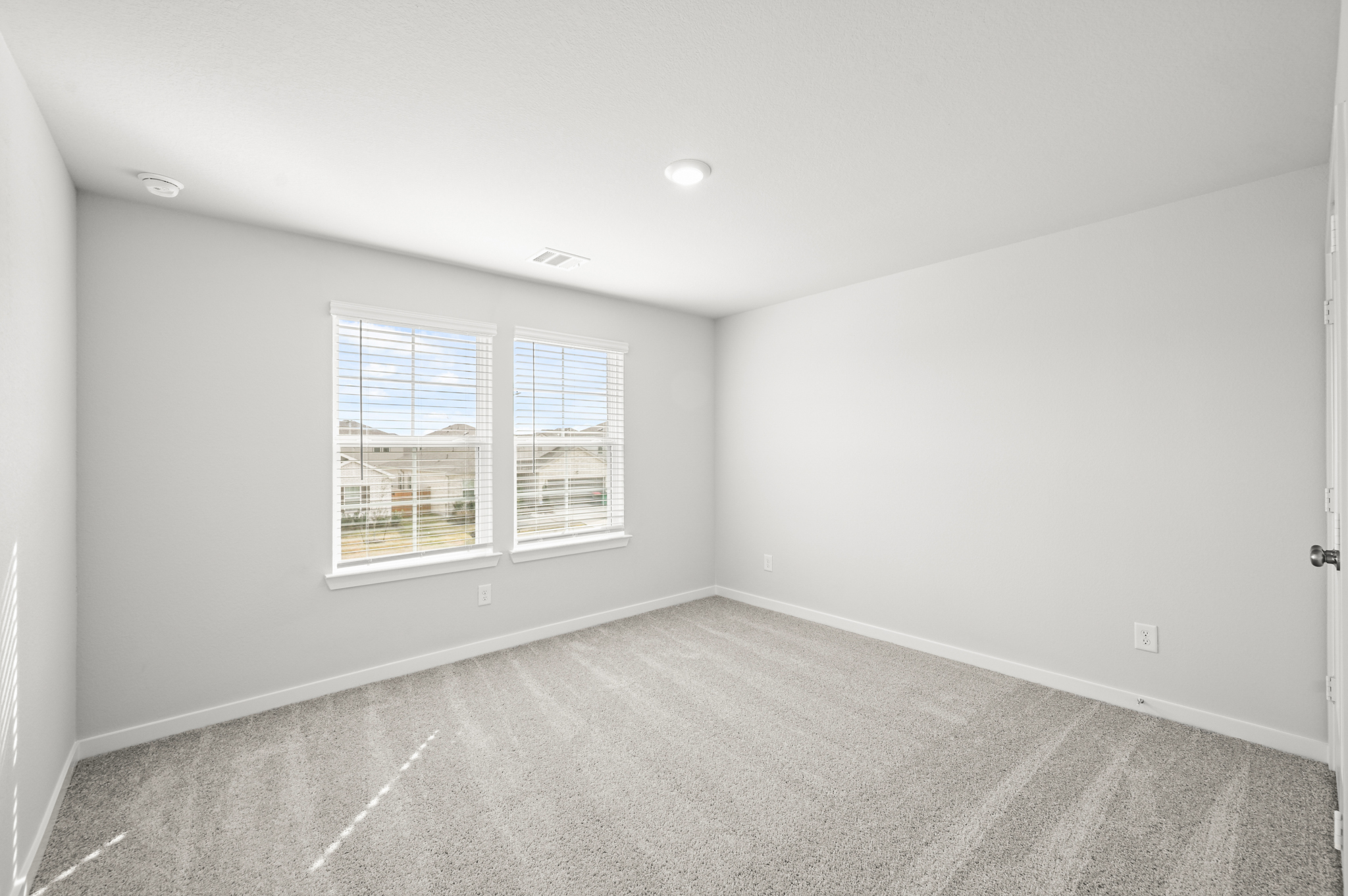 A room with a window and a carpet.