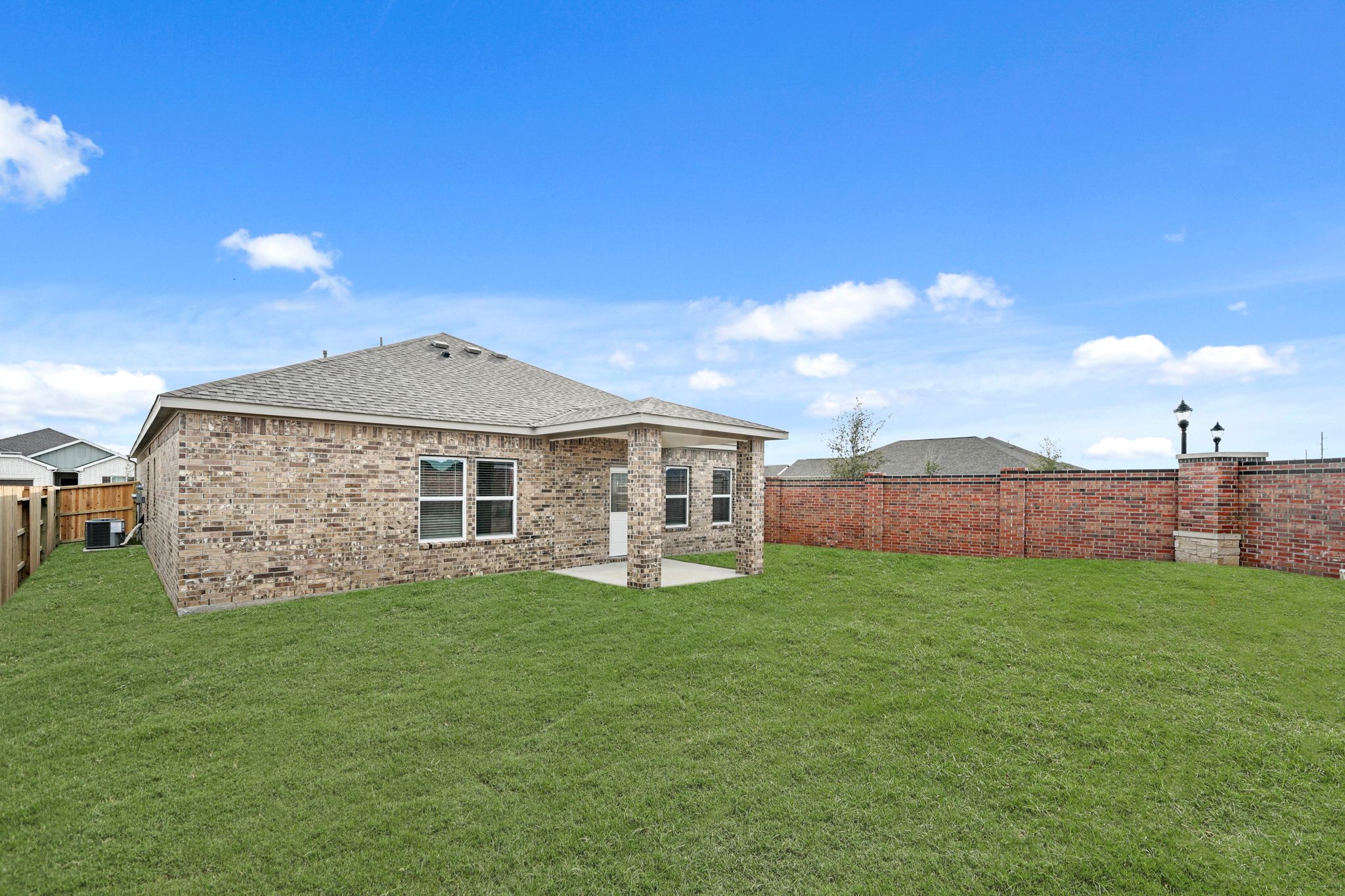 A brick building with a grass yard.