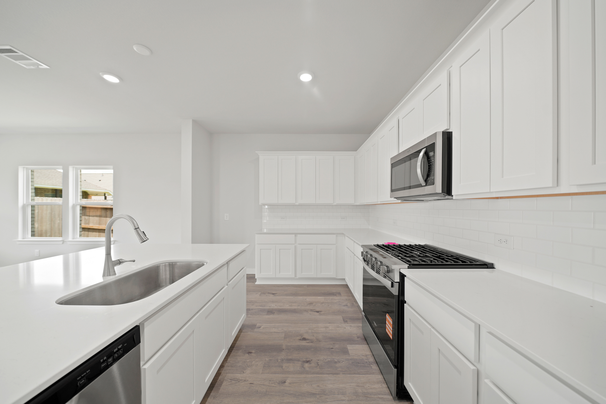 A kitchen with white cabinets.