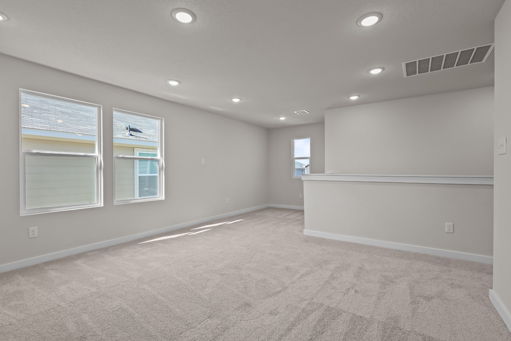 A room with a carpet and windows.