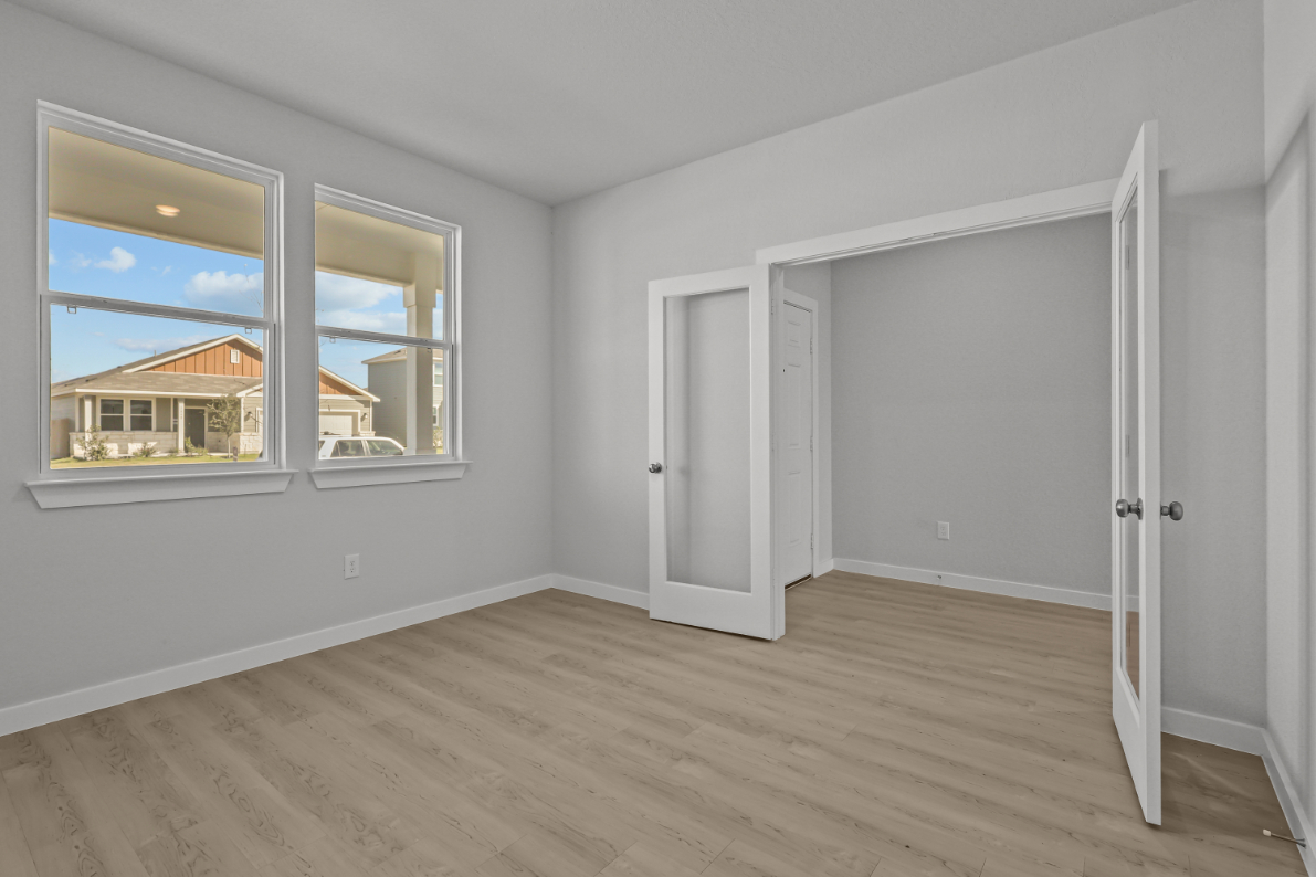 A room with a wood floor and a window with a view of the ocean.