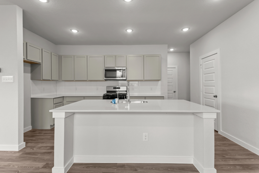 A kitchen with white cabinets.