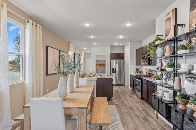 A kitchen with a dining table and shelves.