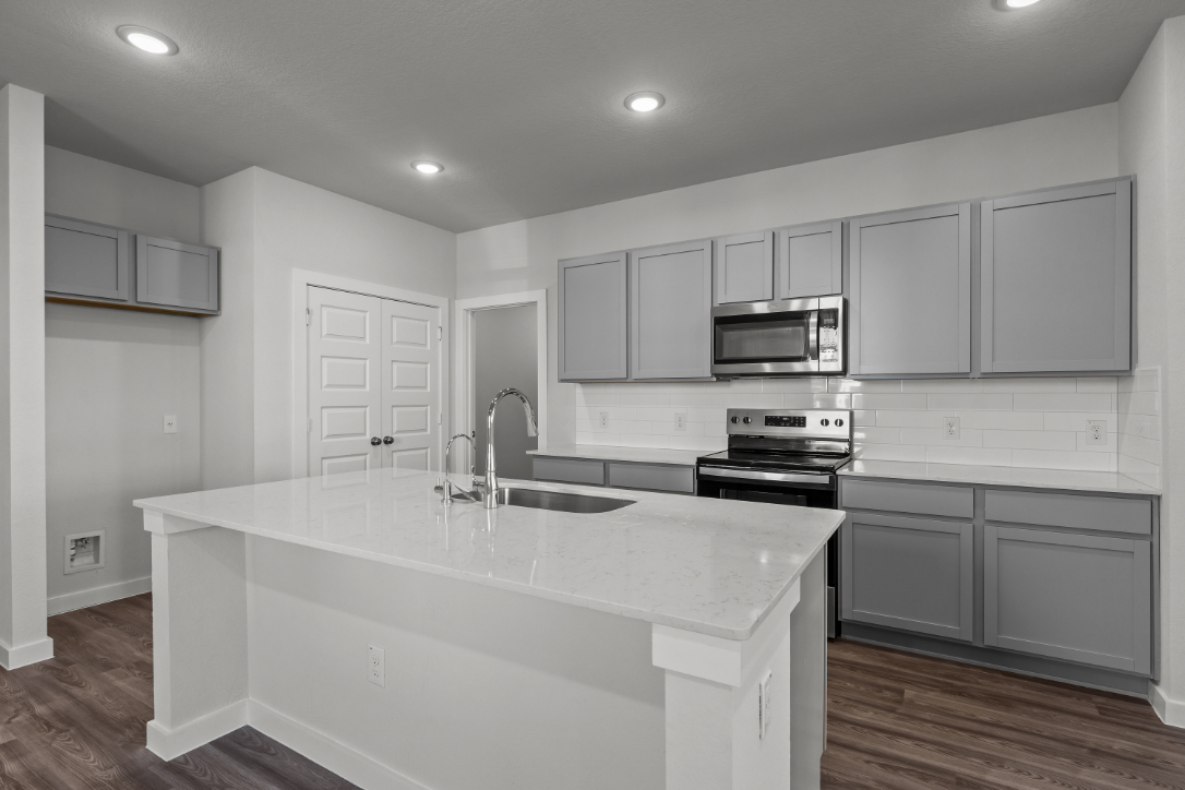 A kitchen with white cabinets.