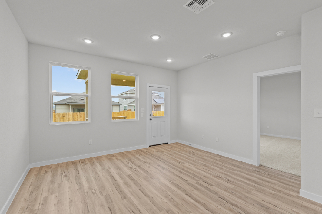 A room with white walls and a wood floor with a wood floor.
