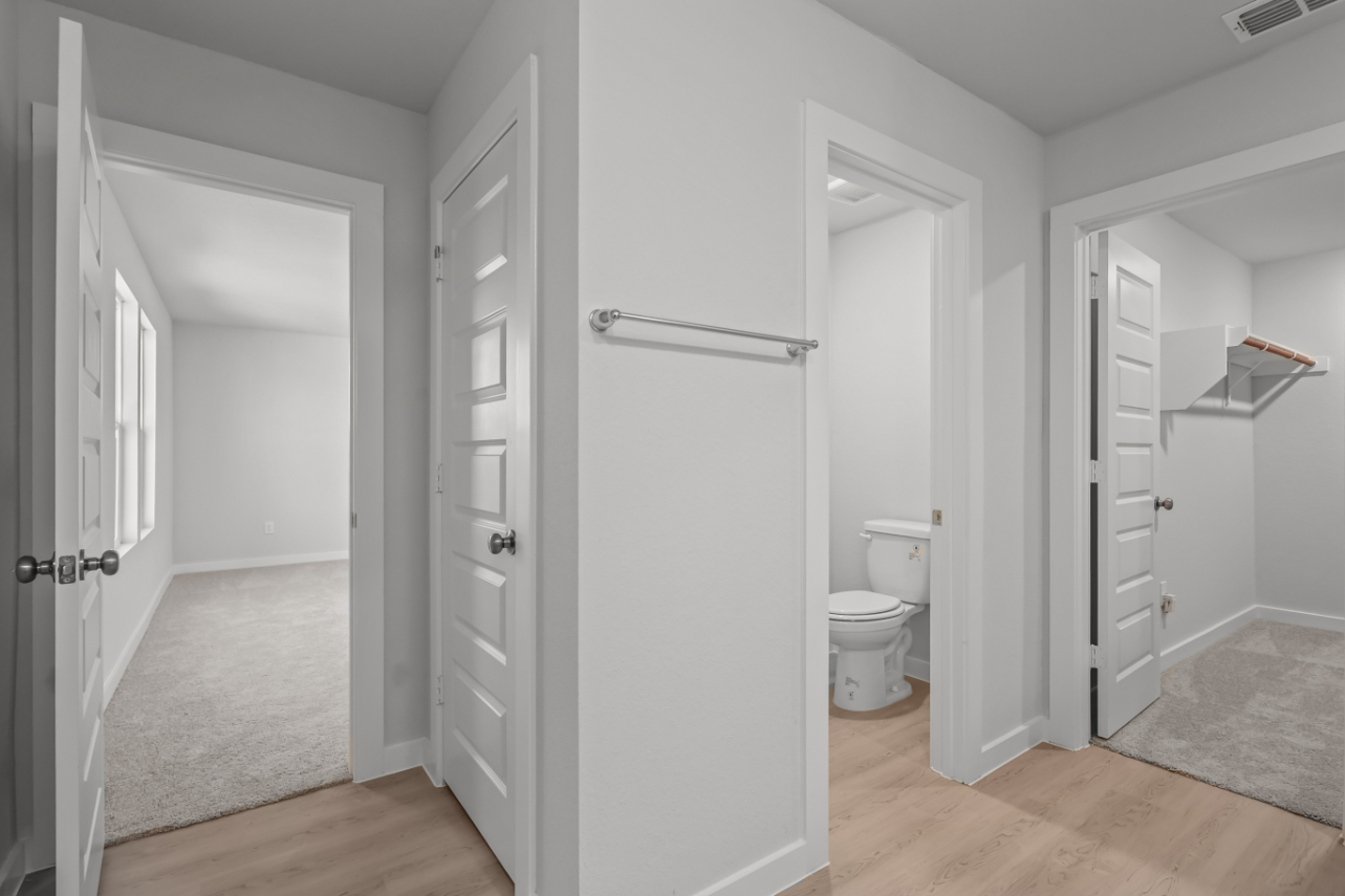 A bathroom with white cabinets.