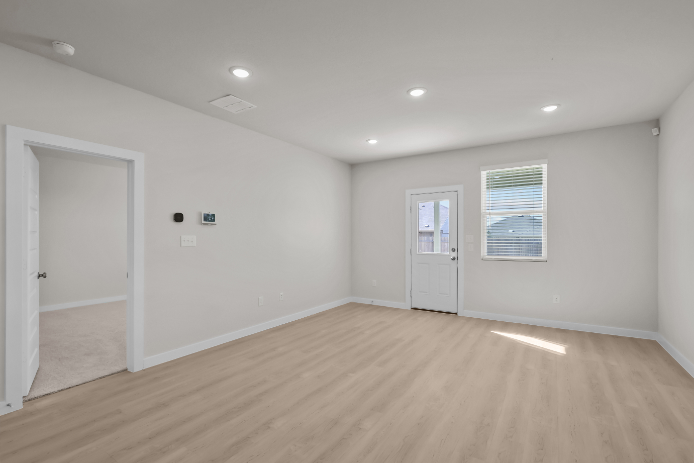 A room with white walls and a wood floor.