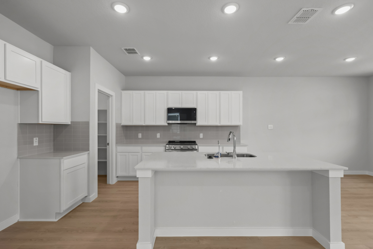 A kitchen with white cabinets.