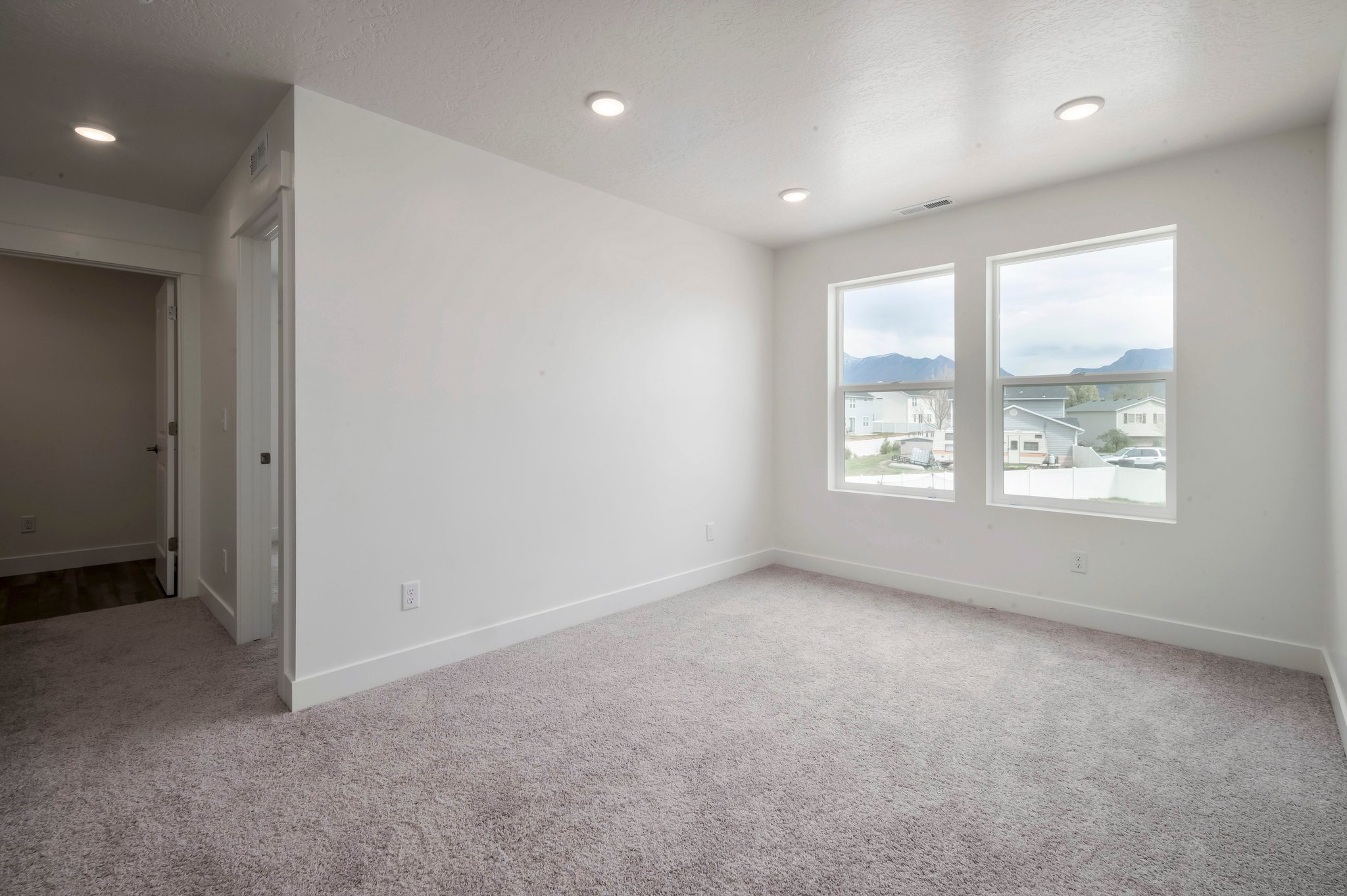 A room with a carpet and windows.
