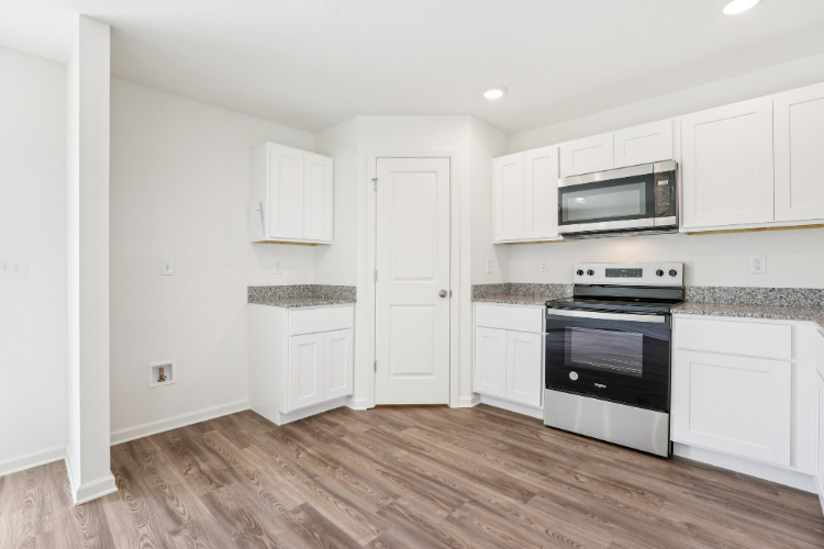 A kitchen with white cabinets.