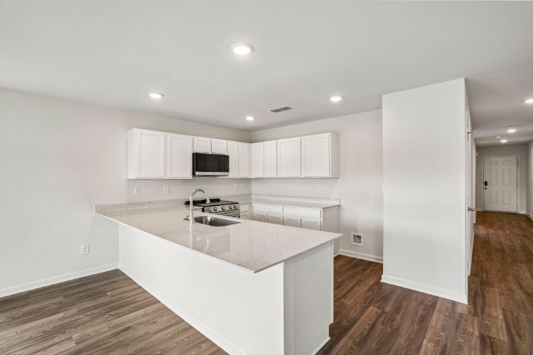 A kitchen with white cabinets.
