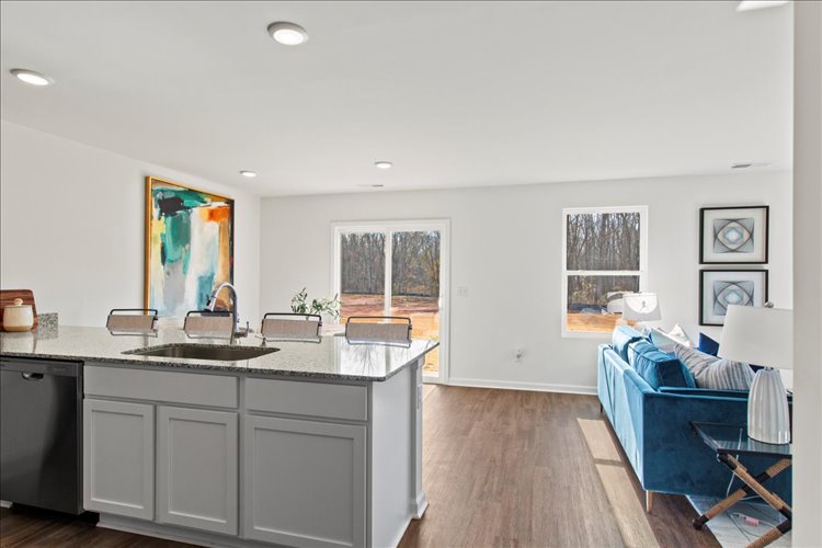 A kitchen with a couch and sink.