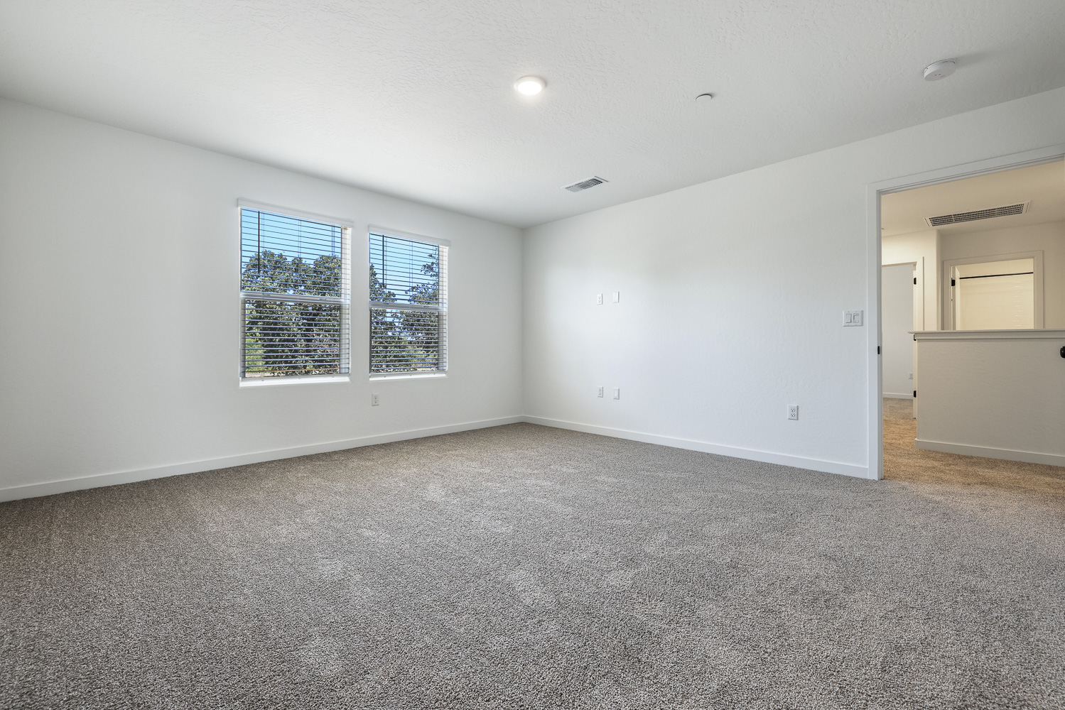 A room with a carpet and a window.